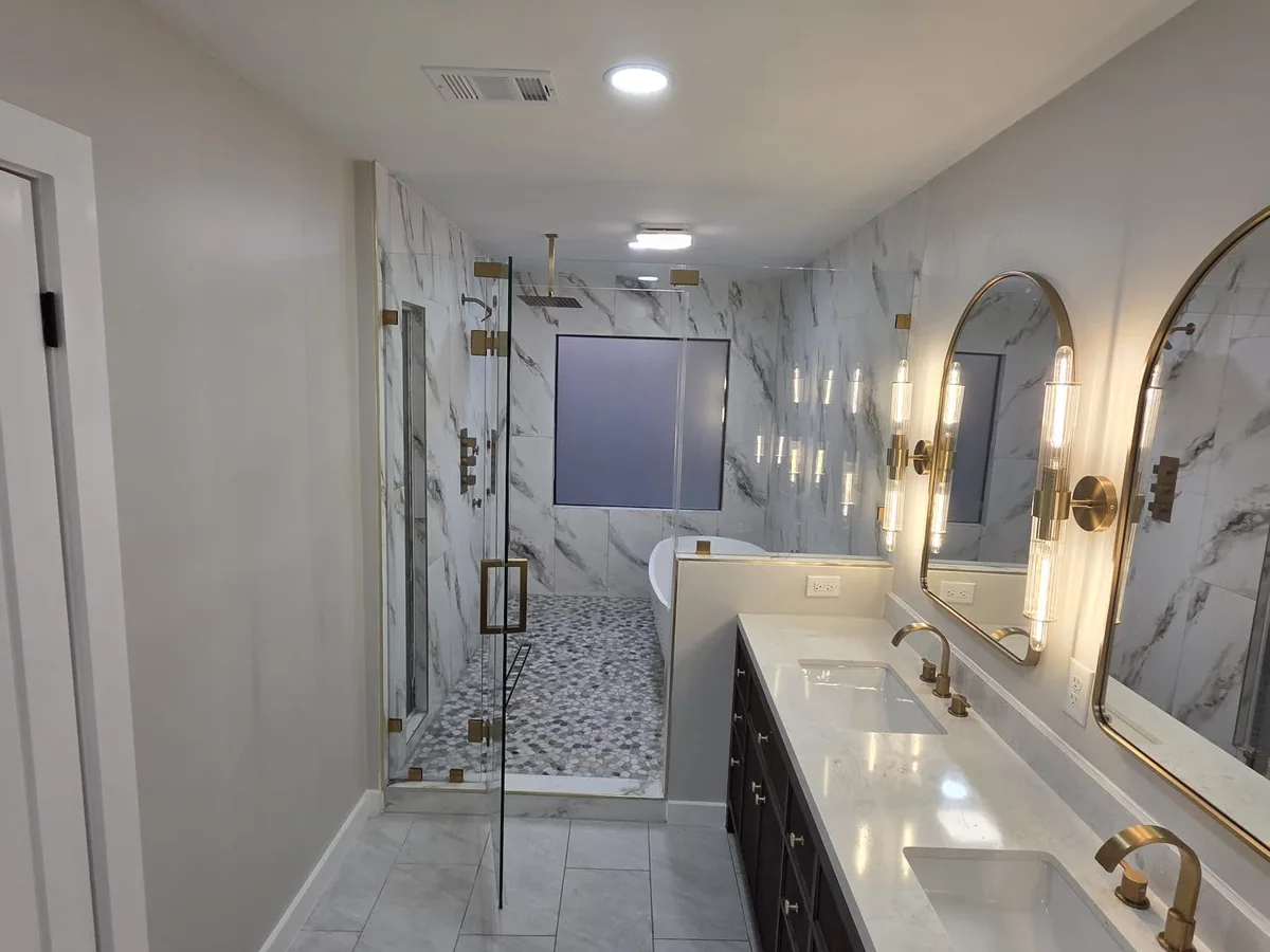 Long bathroom with a double vanity and a walk-in shower at the end