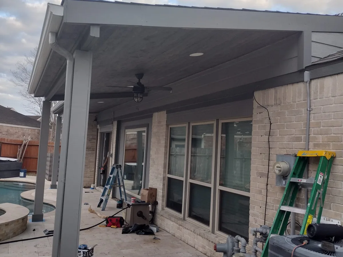 Finished covered patio with a ceiling fan and columns