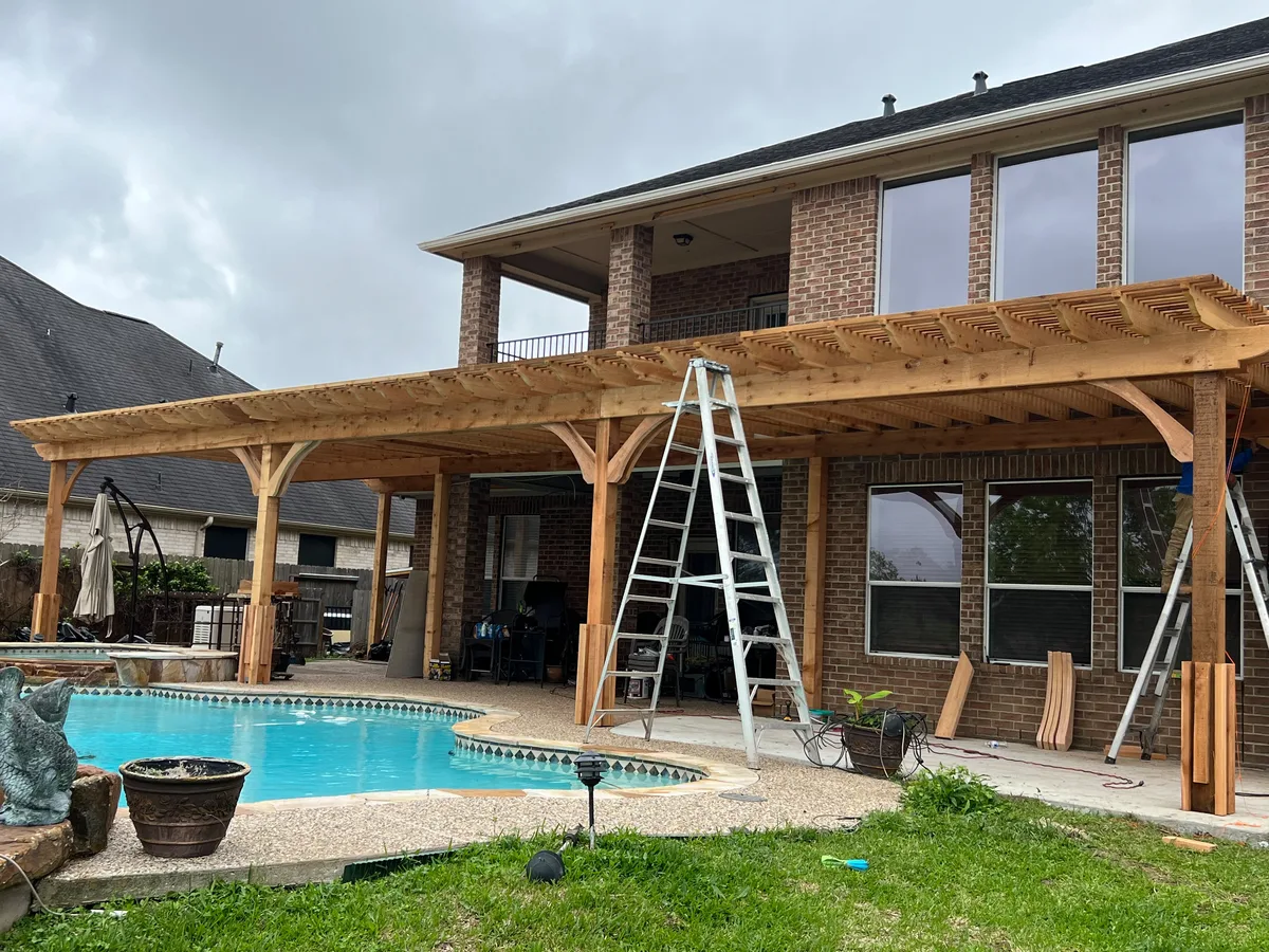 Cedar pergola over a pool during construction