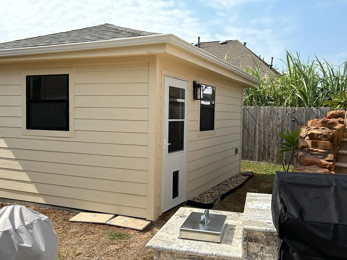 Side of a backyard shed with siding and a window
